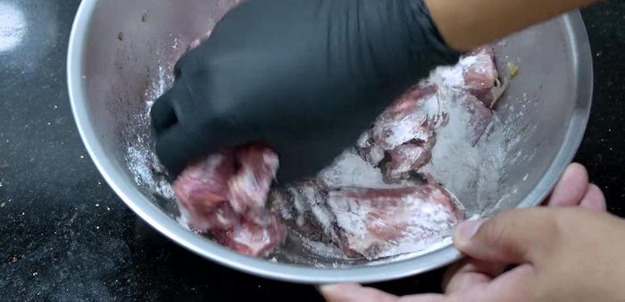 Add crispy fried flour to the marinated pork ribs and mix thoroughly to coat the pieces.