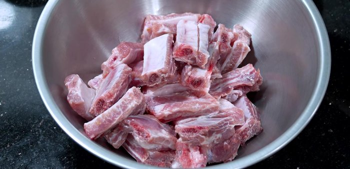 In a bowl, combine pork ribs, crushed garlic, pork seasoning powder, fish sauce, salt, and a little clean water. Mix well and marinate for at least 30 minutes, or longer if possible.