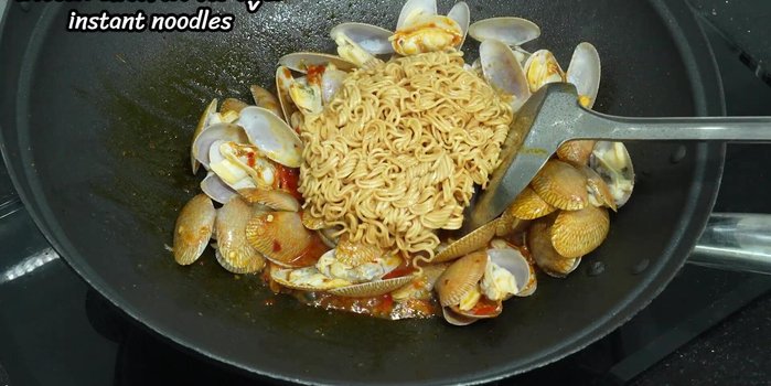 Add the cooked noodles and stir-fry until well combined.
