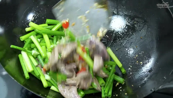 Add the fragrant flowers and stir-fry over high heat.