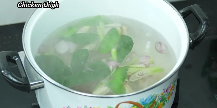 Once the water boils vigorously, add the chicken pieces. Do not stir immediately; wait until it boils again.