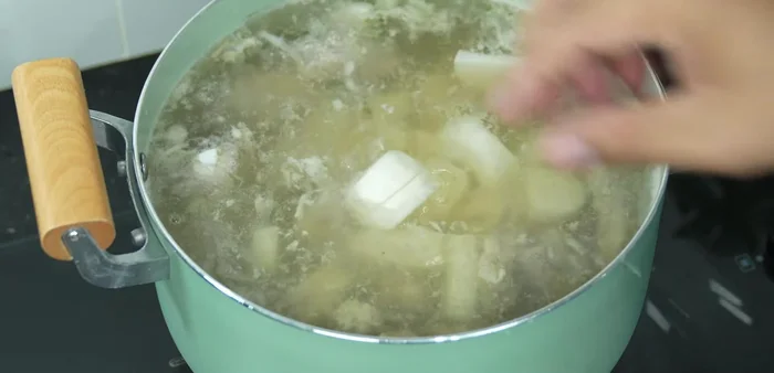 Add radish and dried shrimp: Add the prepared radish and rinsed dried shrimps to the pot.