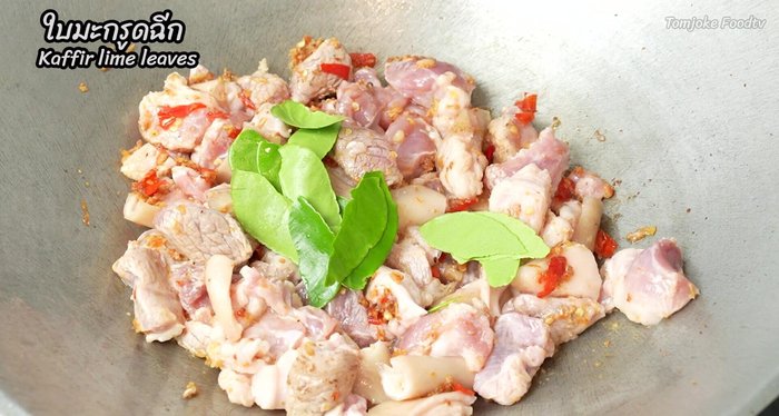 Add half of the kaffir lime leaves and stir-fry to remove the pork smell.
