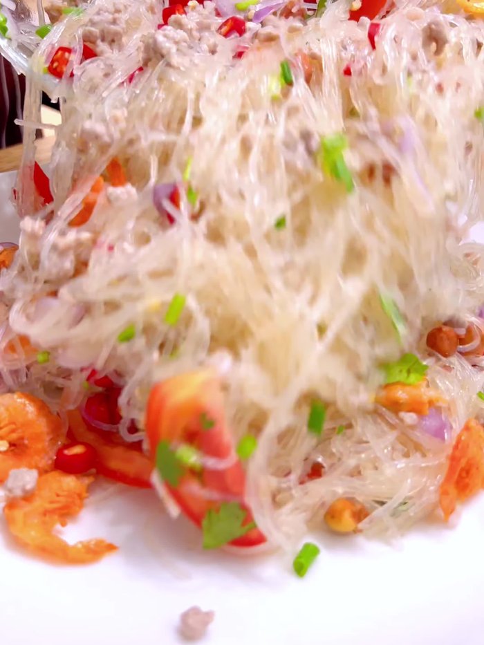 Soak 80 grams of dry glass noodles in water until soft. Then, cut them into shorter lengths using scissors.
