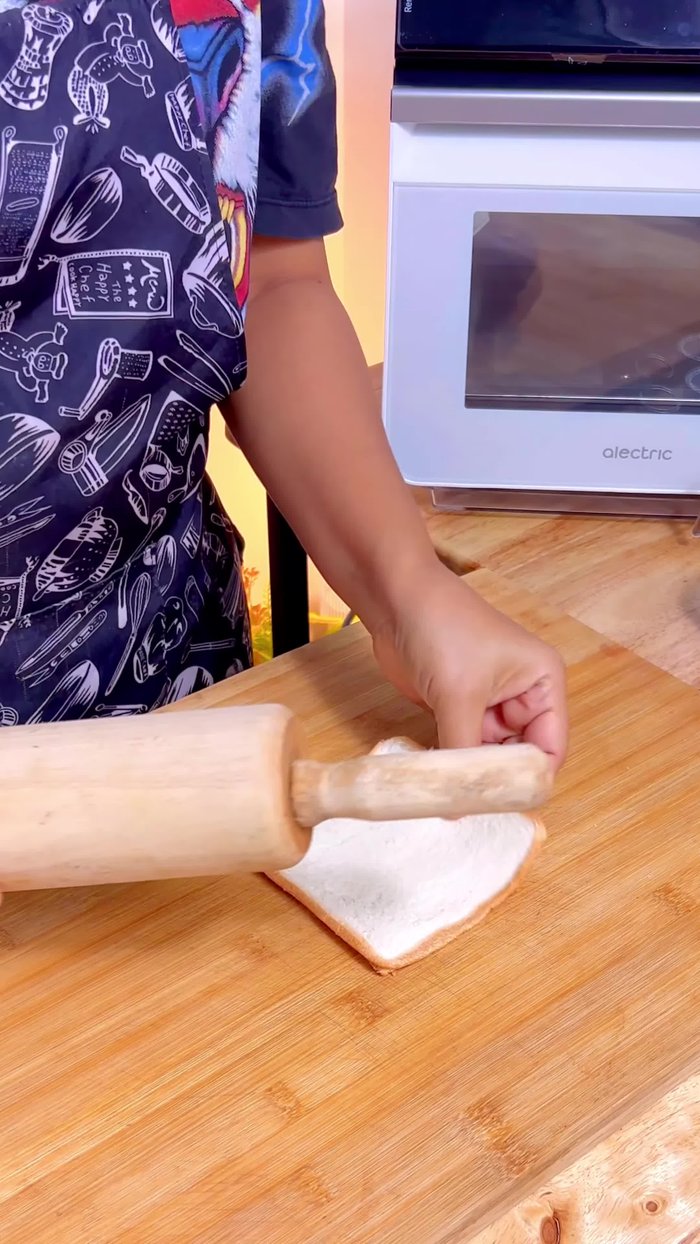 Roll out the bread slices thinly using a rolling pin.