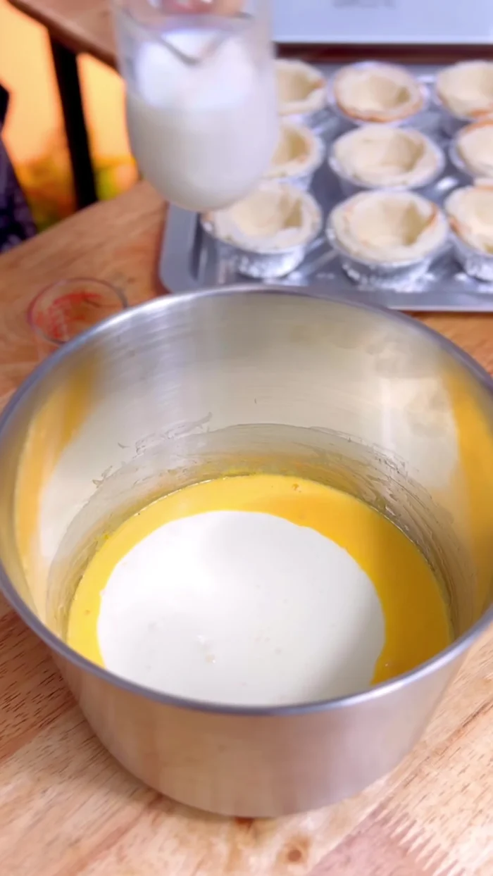 Add 250 grams of whipping cream, 50 ml of fresh milk, and 1 teaspoon of vanilla extract. Mix gently until bubbly.