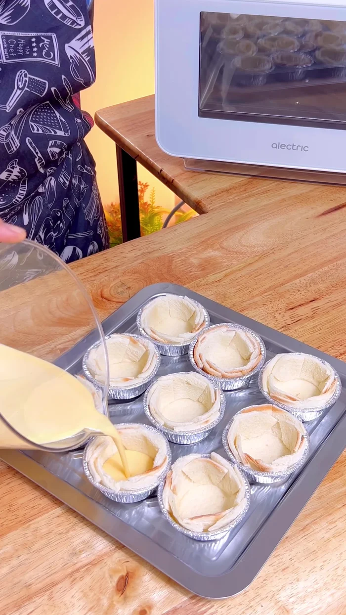 Pour the egg cream into the prepared bread cups, almost filling them.