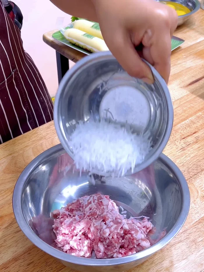 Prepare pork and glass noodles mixture: Combine minced pork, glass noodles (cut into short strips), chili, ground Thai pepper, seasoning sauce, white vinegar, and seasoning powder. Massage until sticky and bouncy.