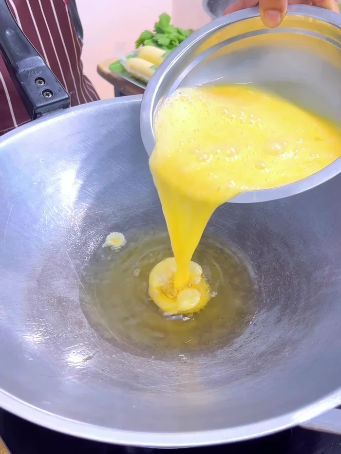 Fry eggs in hot oil until golden brown on both sides. Ensure eggs are fluffy.