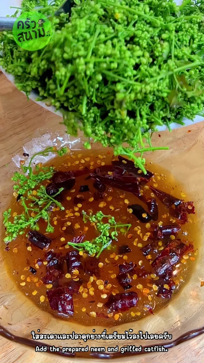 Add the prepared neem leaves and flaked grilled catfish to the sauce mixture. Mix everything thoroughly.