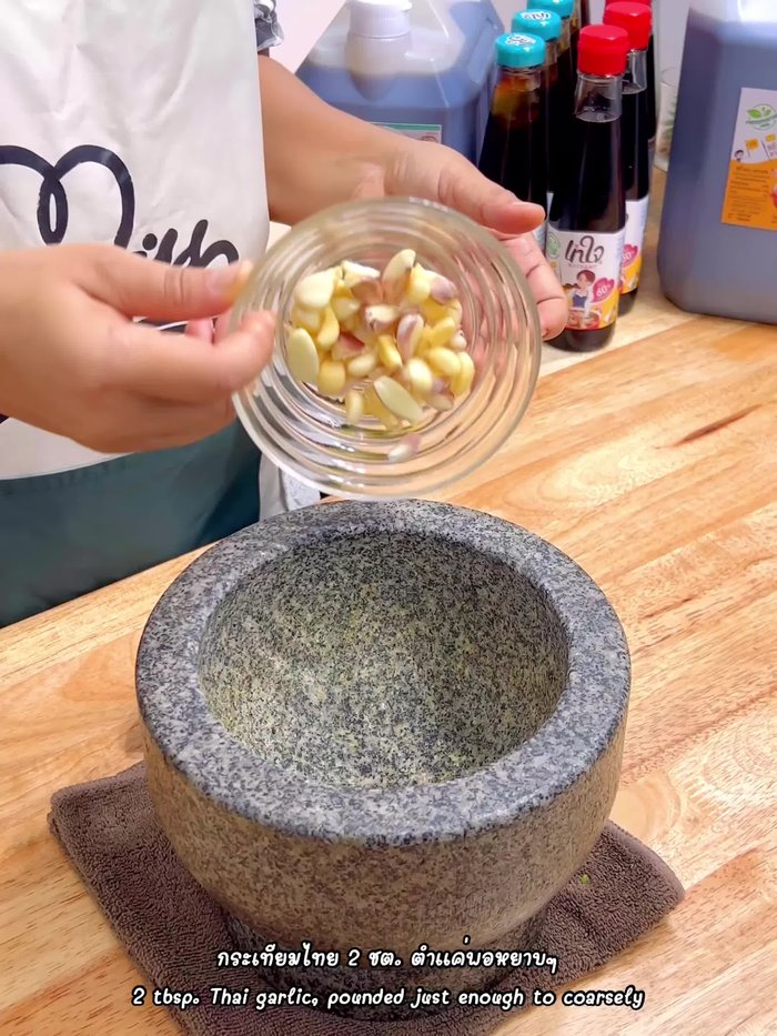 Pound 2 tablespoons of Thai garlic coarsely.