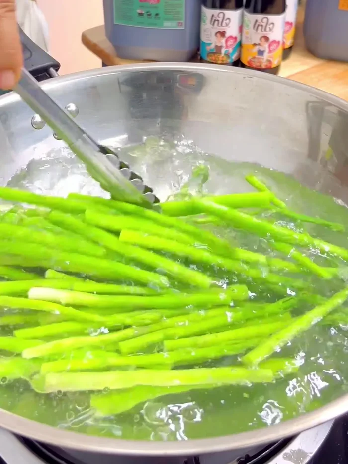 Blanch the asparagus for 5 minutes. Then immediately transfer to a bowl of ice water to stop the cooking process and maintain vibrant color. Drain well.