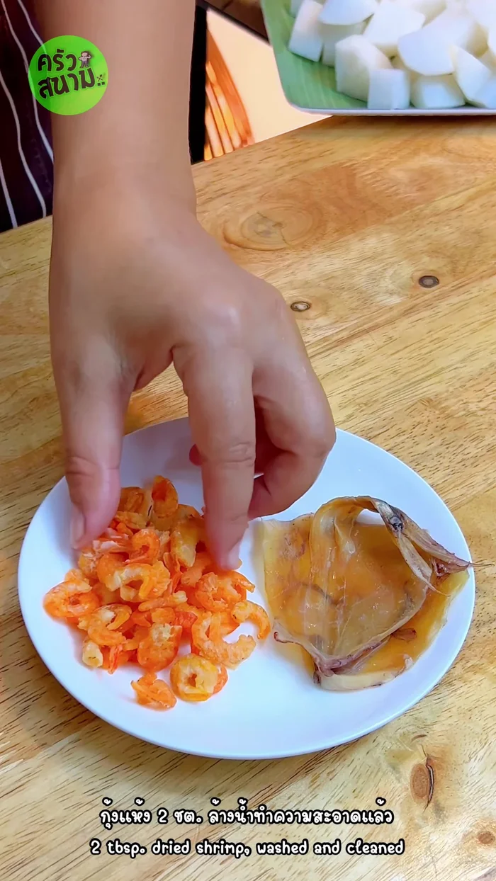 Wash and clean 2 tablespoons of dried shrimp and soak 2 pieces of dried squid in water. Cut them into small pieces. (100.04)