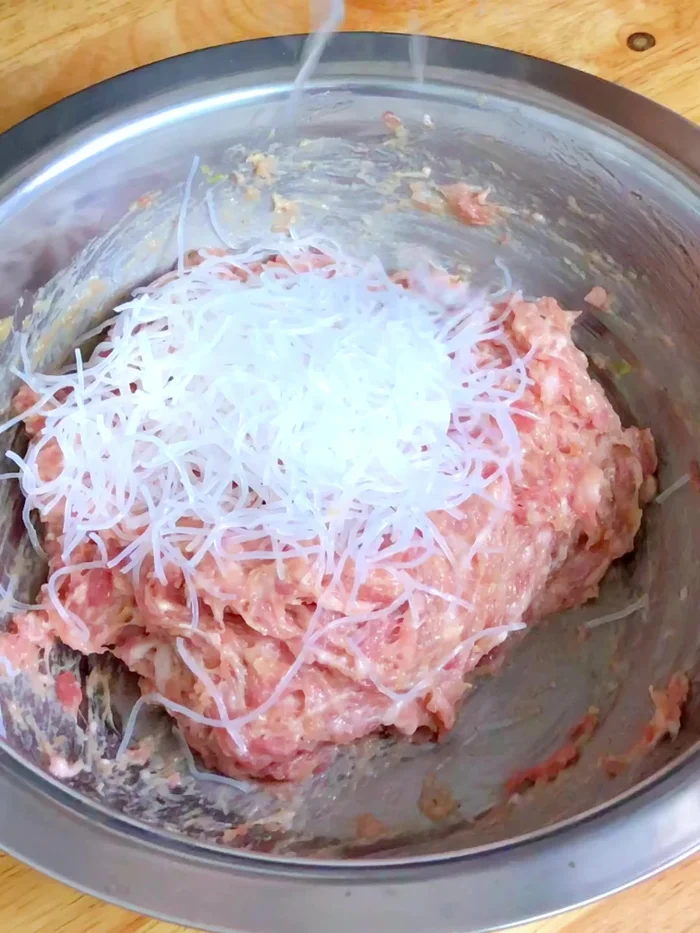 Cut 50 grams of fresh glass noodles into short pieces and knead them into the pork mixture until sticky.