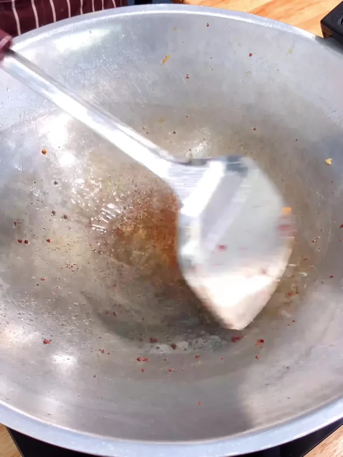 In a pan, heat 1 tablespoon of vegetable oil on low heat. Add 5 tablespoons of tamarind juice, 2 tablespoons of fish sauce, 2 tablespoons of coconut sugar, and 1 teaspoon of salt. Simmer.