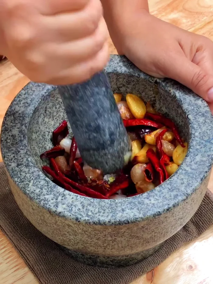 Pound the roasted garlic, chilies, and shrimp paste together until smooth.