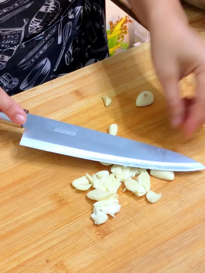 Prepare the garlic: Crush and finely chop 10 cloves of garlic (124.28).