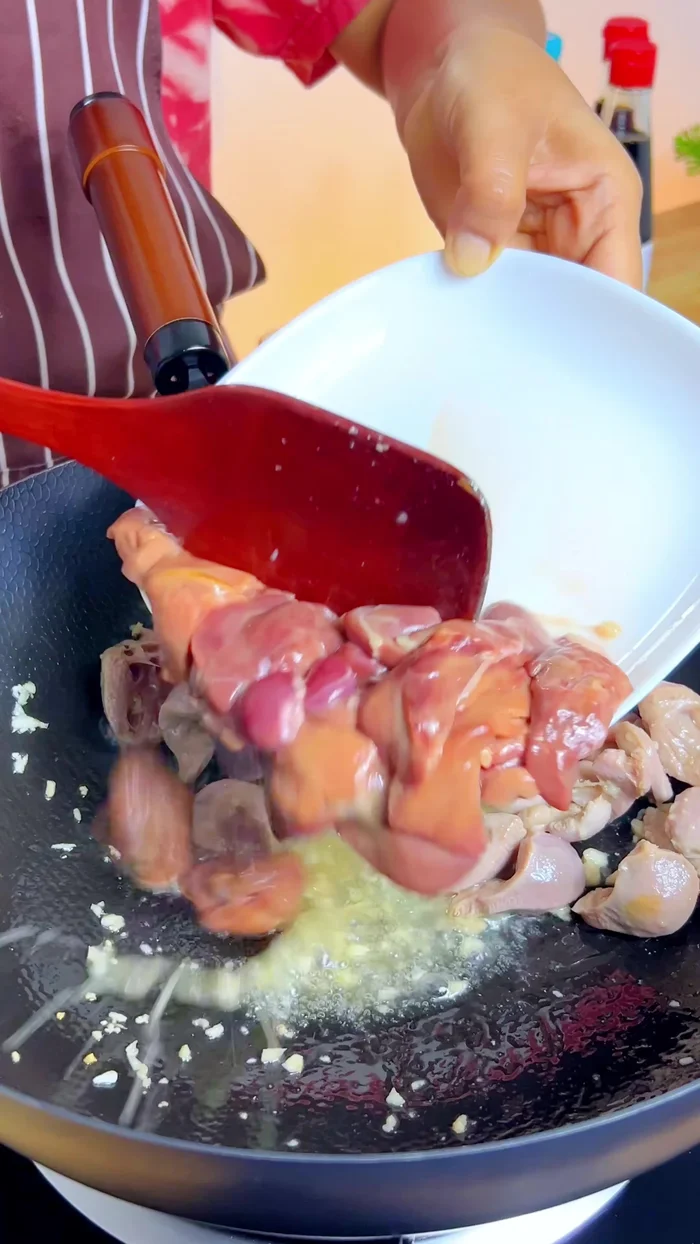 Add the liver, wait until it starts to set before stir-frying further.