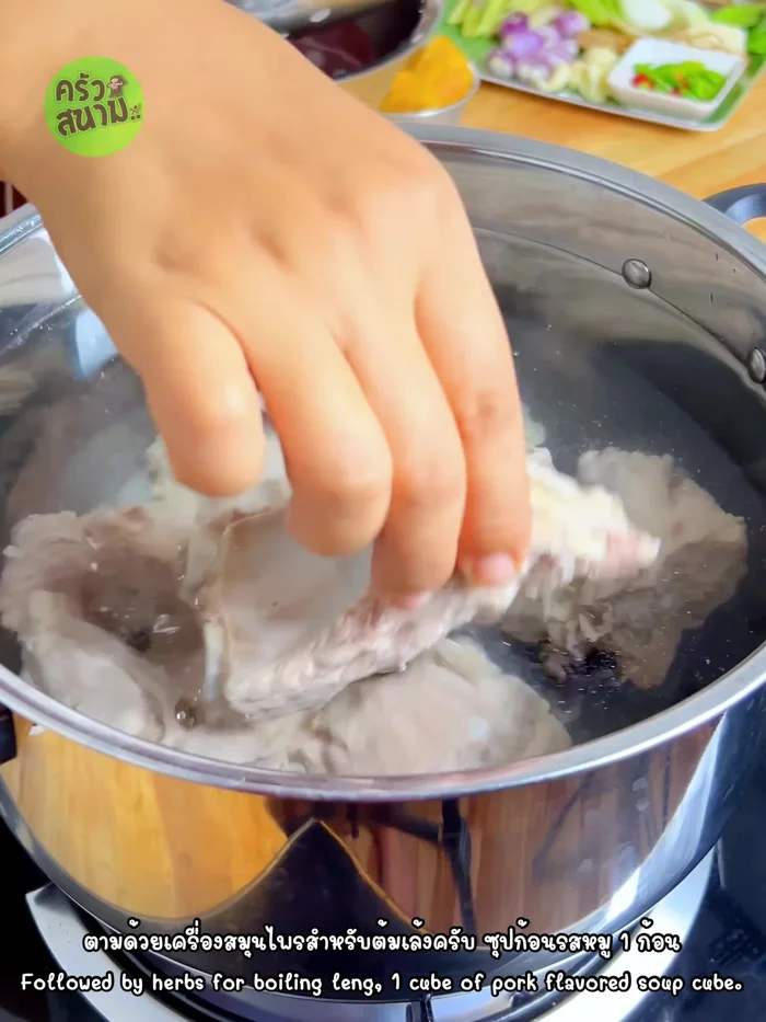 In a pot, combine 3000ml of water, pork ribs, 1 pork cube, 3 smashed and sectioned lemongrass stalks, 5 smashed galangal slices, smashed coriander roots, 5 kaffir lime leaves, 7 smashed shallots, 5 smashed cloves of Chinese garlic, and 1 onion cut into 4 parts. Add 1 cup of pineapple pieces, ½ tablespoon of salt, and 5 tablespoons of white vinegar.