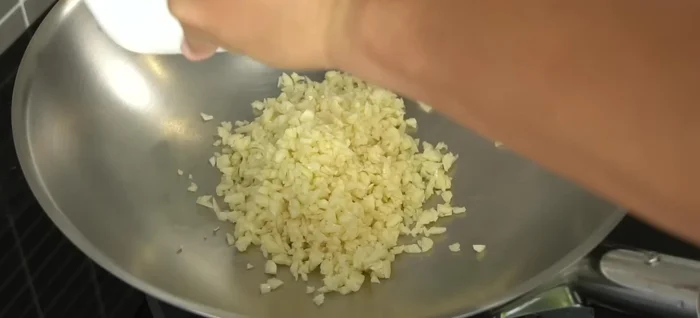 Fry the garlic: In a 31cm Selectra pan, fry the chopped garlic over medium heat with a little salt until golden and crispy. Set aside some fried garlic for garnish and some for mixing with the tofu.