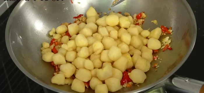 Combine and season: Add the fried egg tofu to the pan with the chili. Season with salt, sugar, and seasoning powder (optional). Stir well to combine.