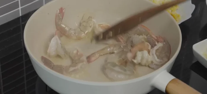 Add shrimp to the hot pan and stir-fry quickly until they turn pink and slightly opaque.