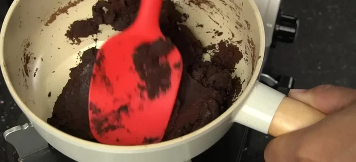 Shape the cocoa mixture into your desired forms while it's still warm. You can make balls, use a mold, or simply leave it in a flat container.