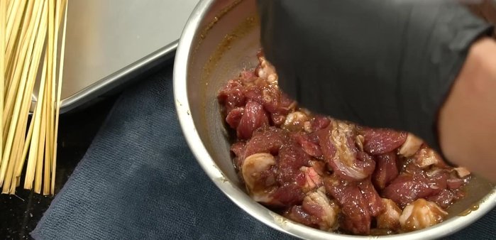 Assemble the pork skewers: Thread the marinated pork onto the skewers, approximately 4-5 pieces per skewer. Tie the skewers together using a knot or spiral method.