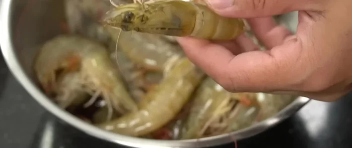 Clean and prepare the shrimp: Drain the water. Cut off the shrimp heads using scissors. Remove the stomach and black veins. You can choose to leave the shell on or off.