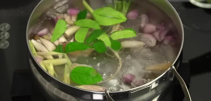 Add tomatoes (soft tomatoes first if preferred) and chili peppers to the boiling soup.