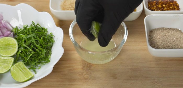 Prepare the dipping sauce: Mix lemon juice, fish sauce, sugar, chili powder, roasted rice, shallots, and coriander.
