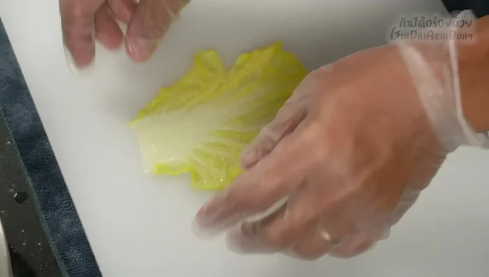 Assemble the rolls: Spread a cabbage leaf, add a spoonful of filling, fold the sides inwards, and roll tightly.