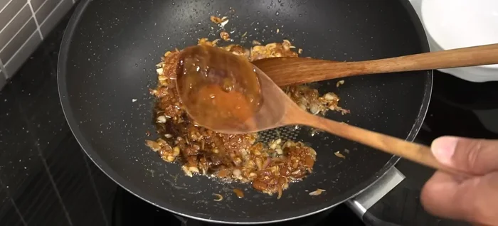 Add fish sauce, Yen Ta Fo sauce/red sauce, tamarind juice, and sugar. Mix well.