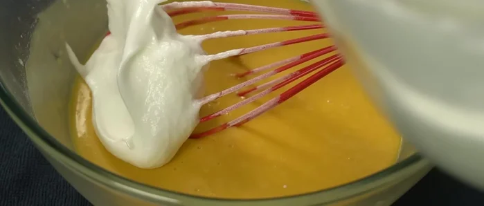 Gently fold the egg whites into the egg yolk mixture in three additions.