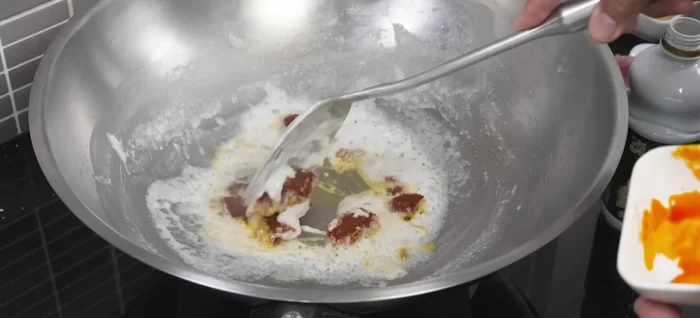 Add panang curry paste and stir-fry until fragrant and the oil separates again.