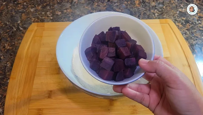 Prepare the dough: Mix glutinous rice flour and cooked purple sweet potatoes. Gradually add warm water, mixing with hands until a soft, slightly sticky dough forms. Let it rest for 10 minutes.