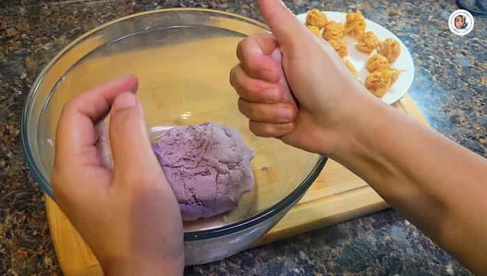 Roll out small portions of dough, wrap each filling ball, and shape into a smooth ball.
