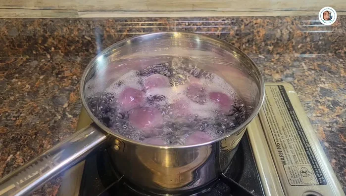 Boil the wrapped dough balls in water until they float to the surface, indicating they are cooked through.