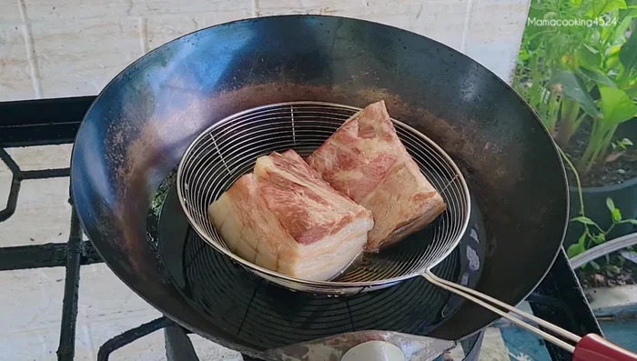 Fry pork belly until crispy and golden brown.