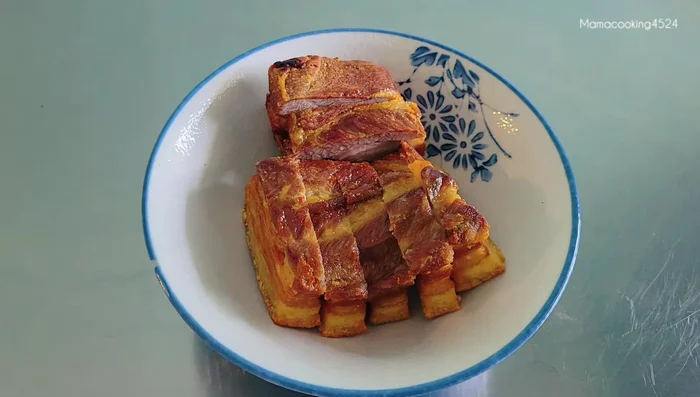 Layer the bottom of a bowl with fried pork belly and stir-fried pickled cabbage.