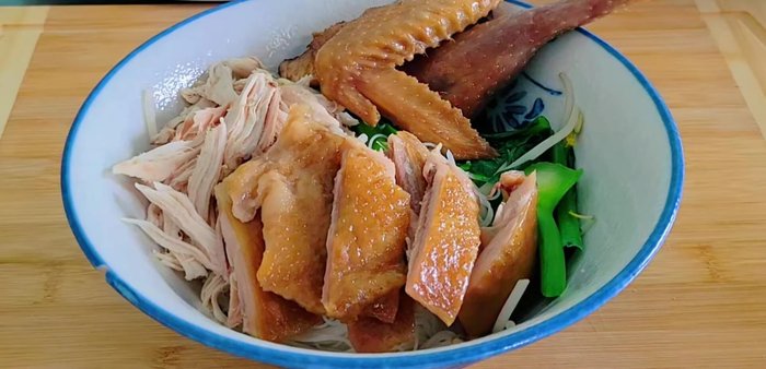 To serve, add shredded chicken, chicken legs and wings, chicken feet, and blood cubes to bowls of soup. Fry garlic, add spring onions and coriander, then pour the soup over and garnish.