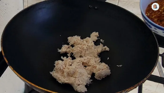 In a pan, heat oil and add the chicken, followed by the small dried chili peppers, large dried chili peppers, garlic, and shallots. Stir-fry over low heat until all ingredients are well combined.