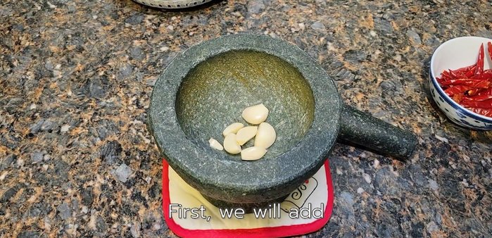 Pound the dried chili peppers and garlic in a mortar and pestle until finely ground and mixed.