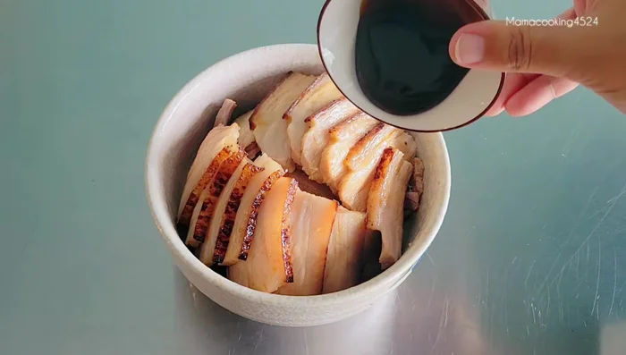 Add soy sauce, oyster sauce, sugar, bay leaves, star anise, cinnamon, dried chilies, and enough beer to almost cover the pork. Add water as needed.