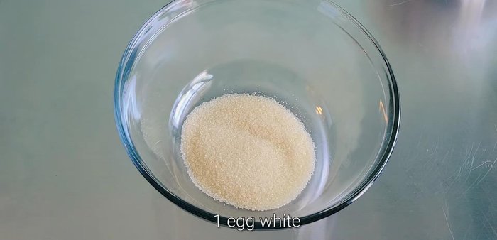 In a separate bowl, combine sugar, egg white, salt, yogurt flavoring, and gradually add warm water, mixing until well combined.
