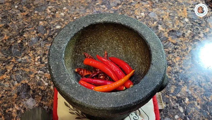 Make the chili paste: Pound dried chilies and red Jinda chilies until smooth. Add palm sugar and mix well.