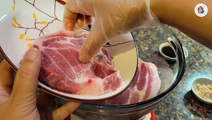 Marinate the pork: Cut 600g pork neck into 2cm thick pieces. Add seasoning powder and oyster sauce, mix well, and let it rest for 15-30 minutes.