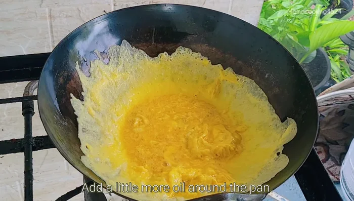 Once cooked, pour a little more oil around the edges of the pan. Scoop the eggs to the edges, then flip.