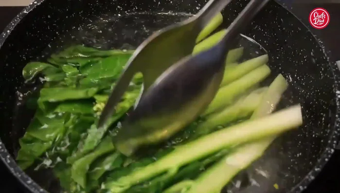 Add the prepared kale to the boiling water and gently press down to ensure even cooking. Blanch for approximately 2-3 minutes, until the kale is tender-crisp.