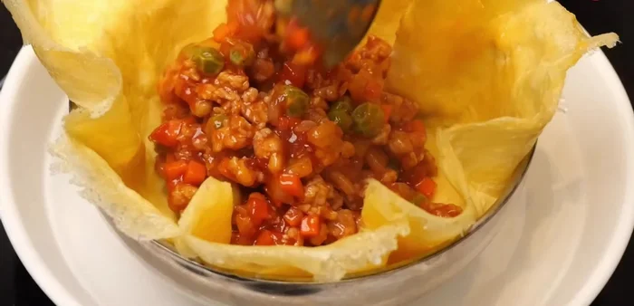Place a spoonful of filling onto each cooked egg, wrap it, and fold into quarters (261.44).